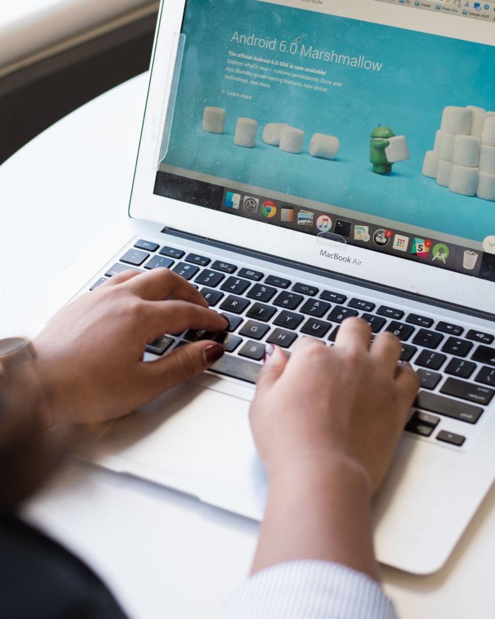 Hands typing on a laptop